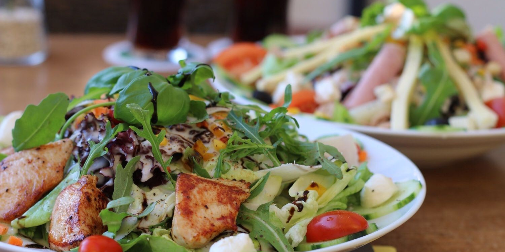 Ein Teller voller bunter Salate schön angerichtet mit frisch gebratenen Putenbruststreifen.